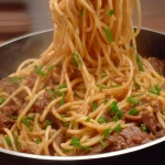 Plato de fideos con carne acompañado de verduras frescas