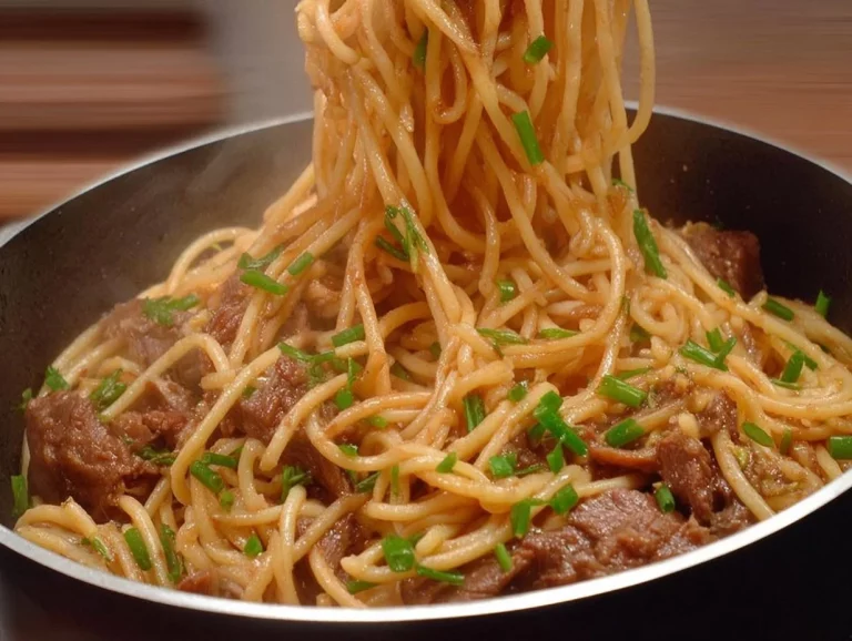 Plato de fideos con carne acompañado de verduras frescas