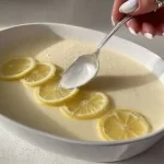 Postre Mousse de Limón servido en un plato con limón fresco al lado.