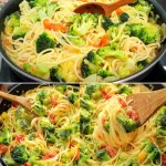 Plato de pasta cremosa con brócolis en una mesa, ideal para disfrutar en casa.