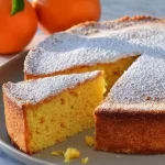 Pastel de mandarina sin harina ni lácteos sobre un plato decorado con rodajas de mandarina.