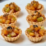 Tartaletas de salmón y pepinillos sobre una mesa elegante