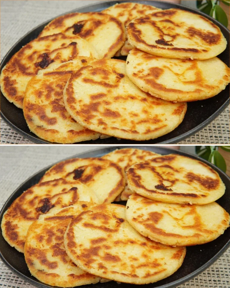 Plato de arepas de queso recién hechas, doradas y rellenas de queso derretido