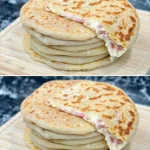 Bollos rellenos fritos recién cocinados y dorados en un plato.